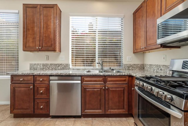 kitchen with sink, stainless steel appliances, and light stone countertops