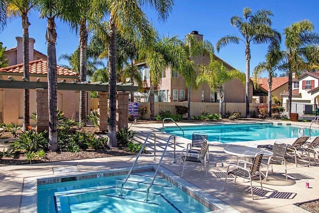 view of swimming pool with a hot tub and a patio area