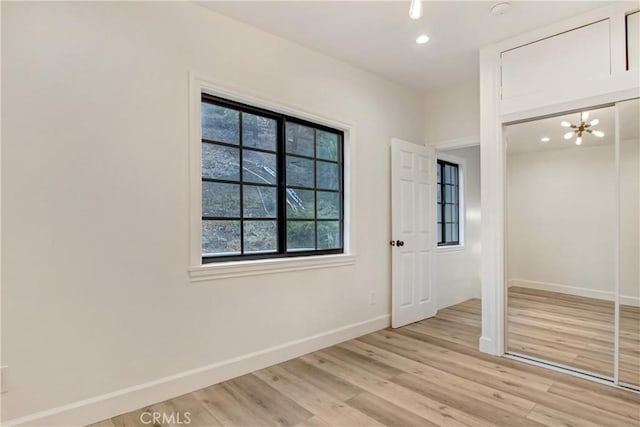 interior space featuring an inviting chandelier and light hardwood / wood-style flooring