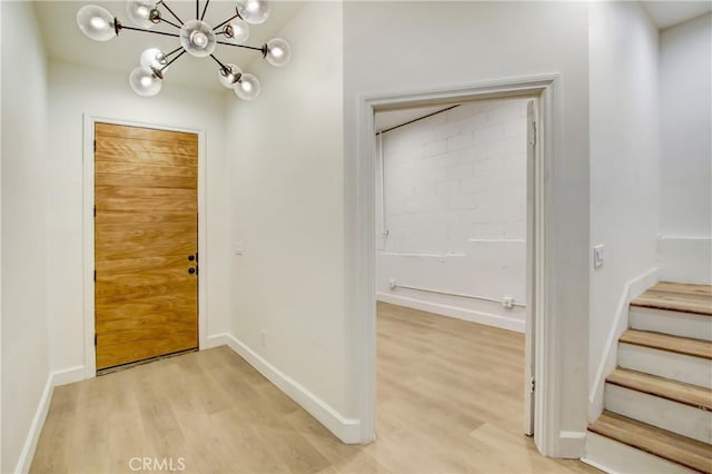 foyer entrance with an inviting chandelier and light hardwood / wood-style floors