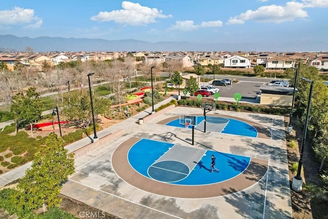 view of pool with a mountain view and basketball hoop