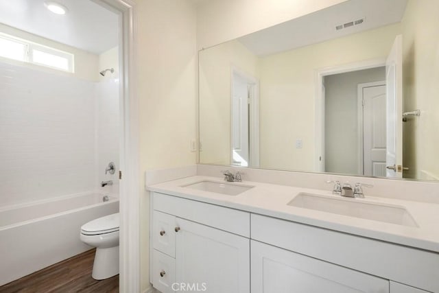 full bathroom with hardwood / wood-style flooring, vanity, toilet, and tub / shower combination