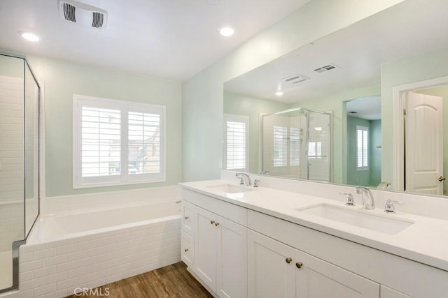 bathroom featuring vanity, hardwood / wood-style flooring, plenty of natural light, and plus walk in shower