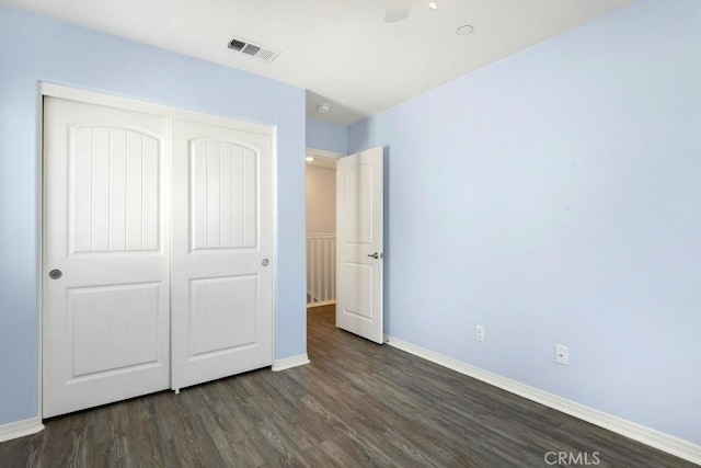 unfurnished bedroom featuring dark hardwood / wood-style flooring, a closet, and ceiling fan