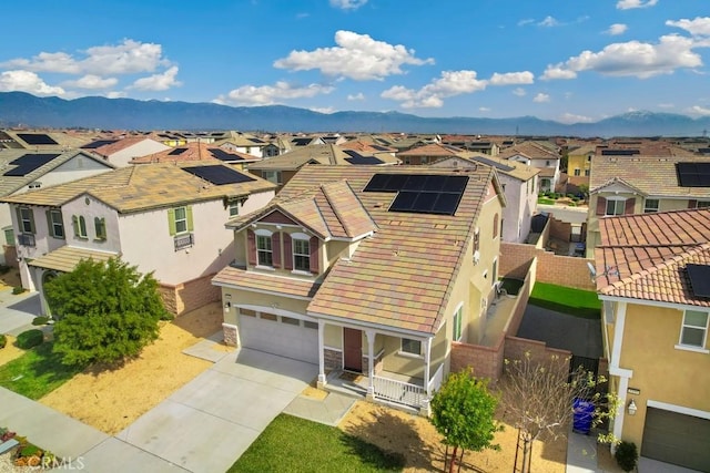 view of front facade featuring a garage, a mountain view, and solar panels