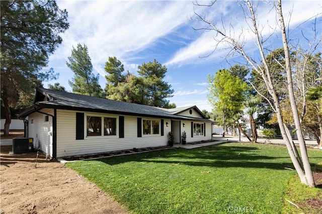 ranch-style home with a front lawn and central air condition unit