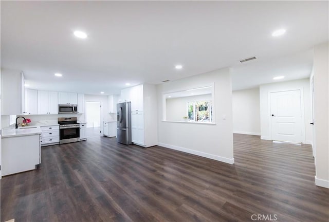 kitchen with sink, dark wood-type flooring, white cabinets, and appliances with stainless steel finishes