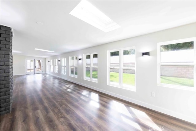 unfurnished living room with french doors, dark hardwood / wood-style flooring, and a skylight