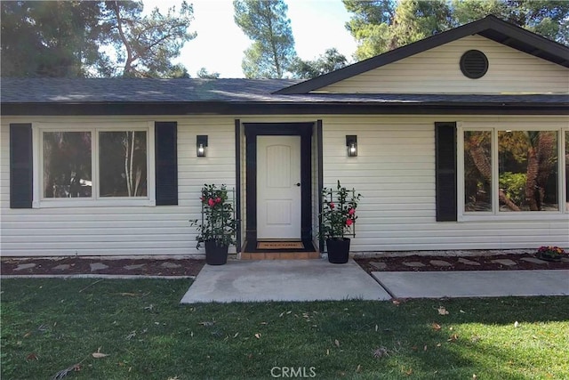 doorway to property with a lawn