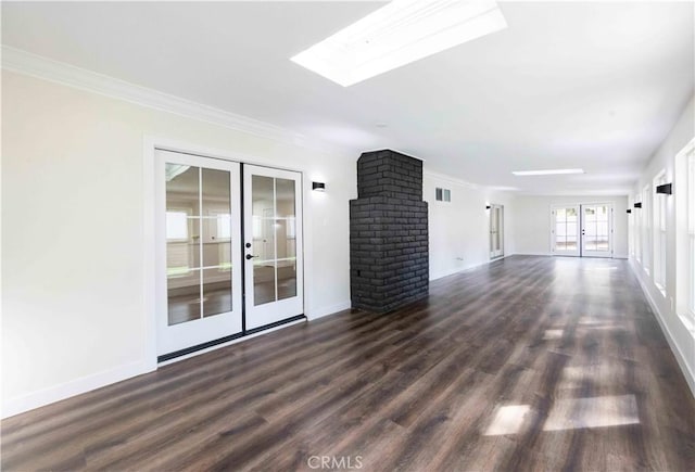 unfurnished living room featuring a skylight, ornamental molding, dark hardwood / wood-style flooring, and french doors