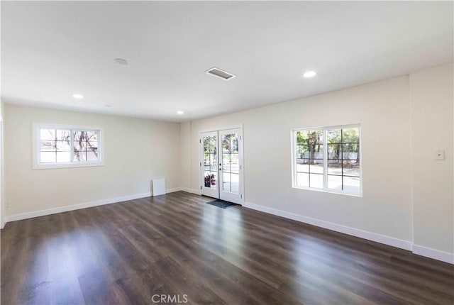 unfurnished room featuring dark hardwood / wood-style floors and a wealth of natural light