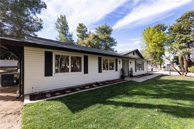 ranch-style home featuring central AC and a front lawn