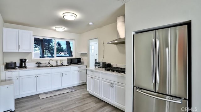 kitchen featuring plenty of natural light, light hardwood / wood-style floors, white cabinets, and appliances with stainless steel finishes