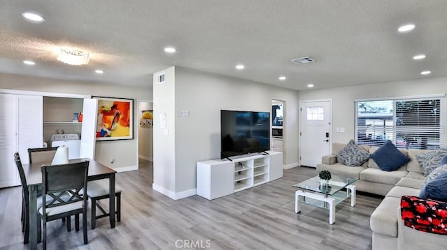 living area with recessed lighting, visible vents, a textured ceiling, and light wood finished floors