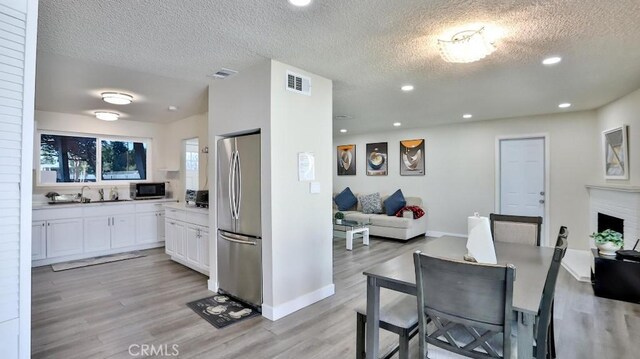 dining area featuring a textured ceiling and light hardwood / wood-style flooring