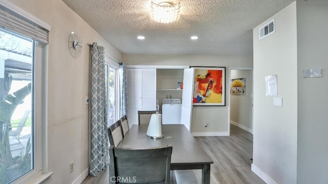 dining space with washer / clothes dryer, a textured ceiling, and light wood-type flooring