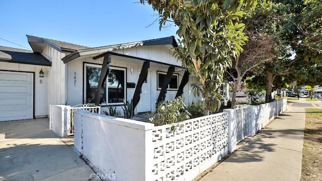 view of side of home with an attached garage and a fenced front yard