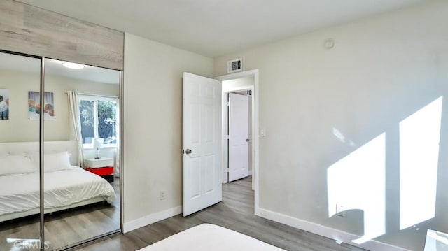 bedroom with hardwood / wood-style floors and a closet