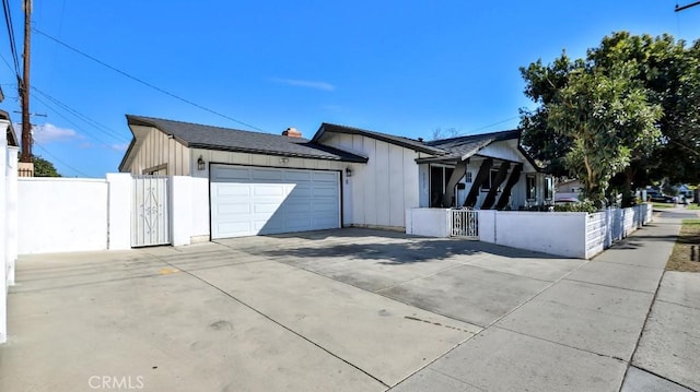 view of home's exterior featuring driveway, a fenced front yard, a gate, and board and batten siding