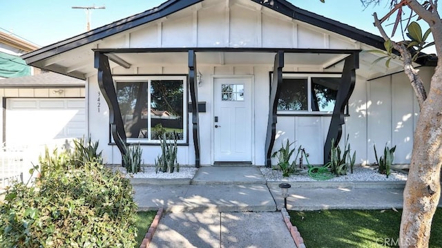 view of exterior entry with board and batten siding and an attached garage