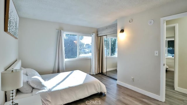 bedroom with wood-type flooring and a textured ceiling