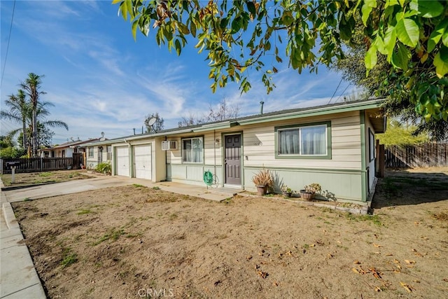 single story home with a garage and a wall mounted AC