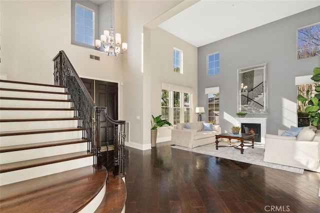 entryway featuring a towering ceiling, hardwood / wood-style floors, and a chandelier