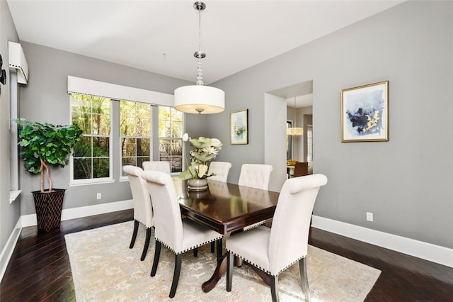 dining space with dark hardwood / wood-style flooring and an AC wall unit