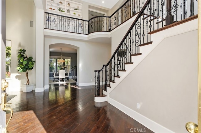 foyer with hardwood / wood-style flooring and a towering ceiling