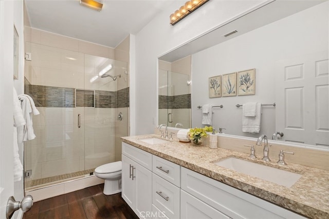 bathroom featuring vanity, toilet, a shower with shower door, and hardwood / wood-style floors