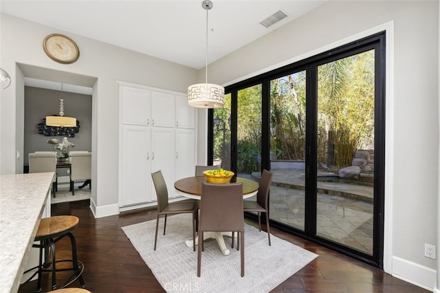 dining space with dark hardwood / wood-style floors