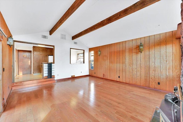 unfurnished living room featuring high vaulted ceiling, wooden walls, light hardwood / wood-style floors, and beamed ceiling