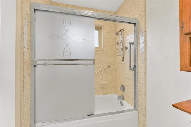 bathroom featuring combined bath / shower with glass door