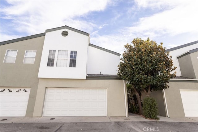 view of property with an attached garage and stucco siding