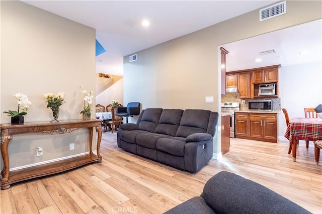 living area featuring recessed lighting, visible vents, and light wood-style flooring