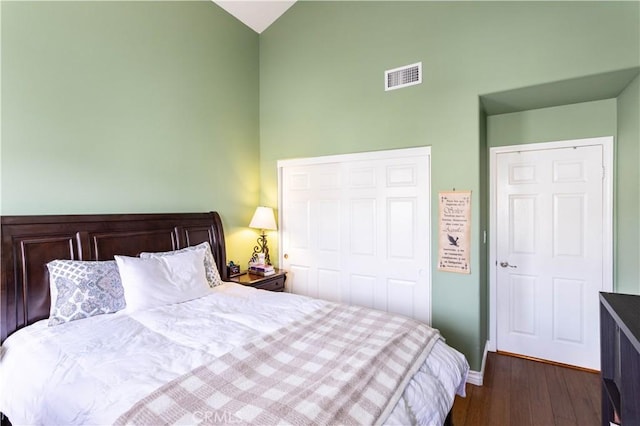 bedroom with high vaulted ceiling, visible vents, baseboards, a closet, and dark wood-style floors