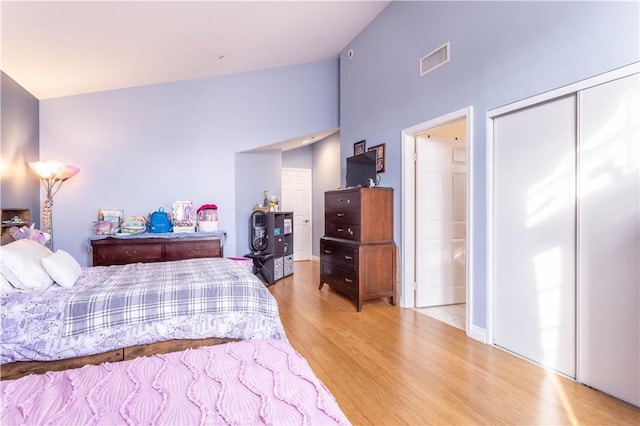 bedroom with light wood-style floors, a closet, and visible vents