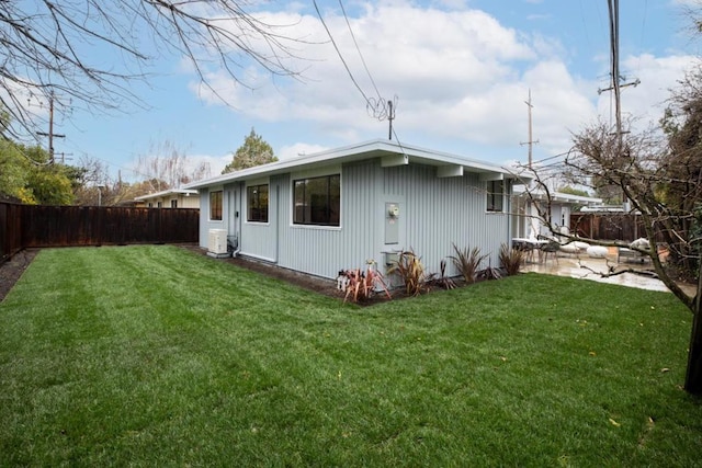 rear view of house with a lawn and a patio