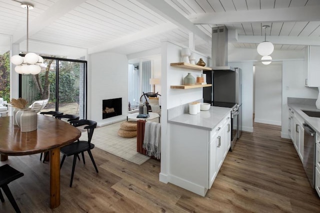 kitchen featuring a large fireplace, pendant lighting, white cabinets, and dark wood-type flooring