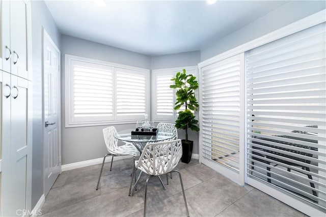 dining space featuring baseboards and light tile patterned floors