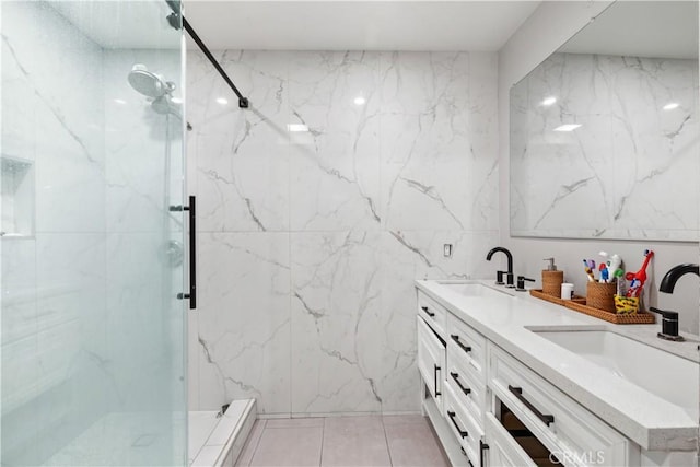 bathroom with tile walls, vanity, tile patterned floors, and tiled shower