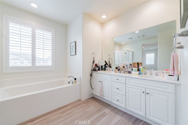 bathroom featuring hardwood / wood-style flooring, vanity, separate shower and tub, and a wealth of natural light