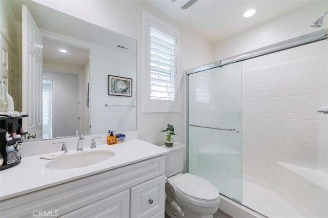 bathroom with vanity, a shower with shower door, and toilet