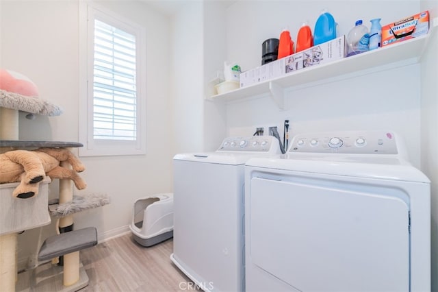 laundry area featuring washing machine and dryer and light hardwood / wood-style floors