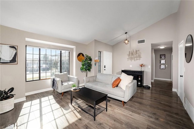 living room featuring dark hardwood / wood-style floors and high vaulted ceiling