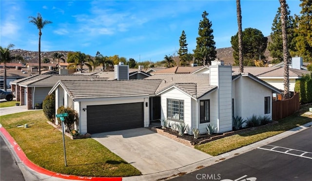 single story home featuring a garage and a front yard