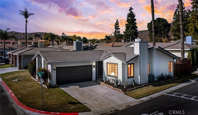 ranch-style house with a garage and a yard