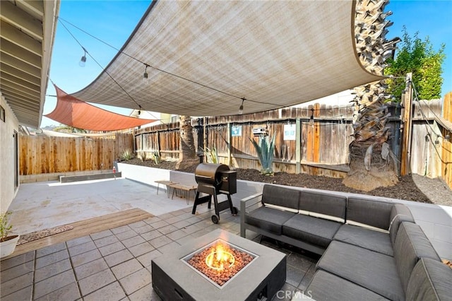 view of patio with area for grilling and an outdoor living space with a fire pit