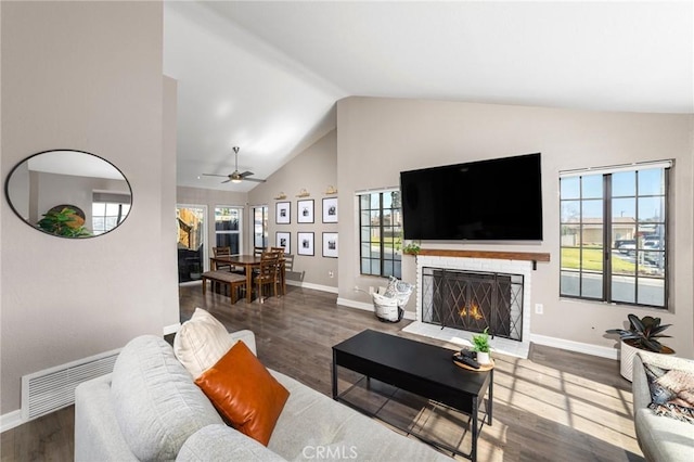 living room featuring wood-type flooring, a healthy amount of sunlight, and high vaulted ceiling