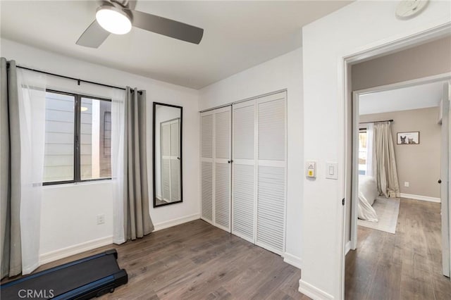 unfurnished bedroom with ceiling fan, dark hardwood / wood-style flooring, and a closet